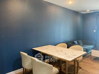 Modern living room with elegant marble dining table and stylish blue accent wall.
