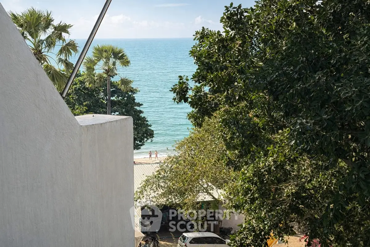 Stunning ocean view from a coastal property with lush greenery and palm trees.