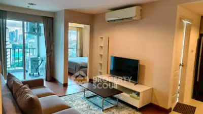 Modern living room with city view and cozy bedroom access
