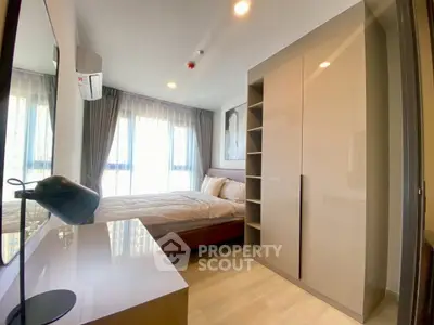 Modern bedroom with large windows and sleek furniture in a stylish apartment.