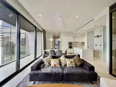 Luxurious modern living room with panoramic city views and elegant open kitchen layout.