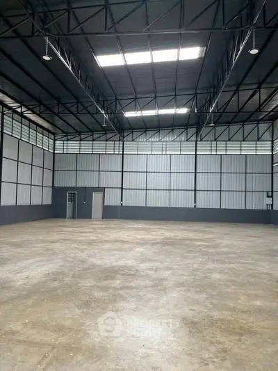 Spacious industrial warehouse with high ceilings and ample natural light.
