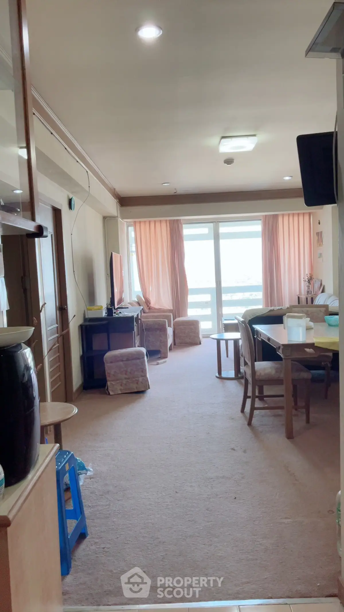 Spacious living room with large windows and cozy seating area