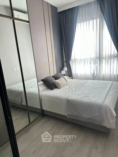 Modern bedroom with stylish decor and large mirrored wardrobe