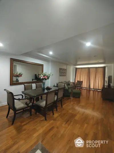 Elegant spacious living room with polished hardwood floors, classic furniture, and tasteful decor, illuminated by modern recessed lighting, perfect for entertaining.