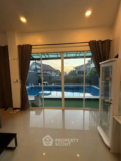 Spacious living room with pool view and large glass doors