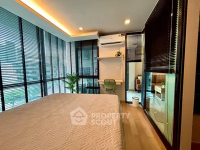 Modern bedroom with large windows and stylish decor in a contemporary apartment.