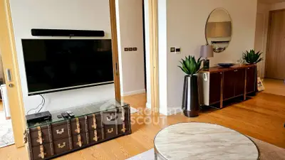 Stylish living room with modern decor and large TV, perfect for relaxation.