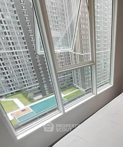 Modern high-rise apartment with large windows offering stunning city views.