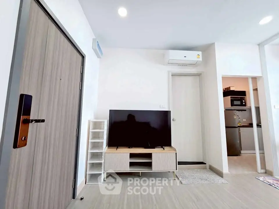 Modern living room with sleek TV setup and air conditioning in a stylish apartment.