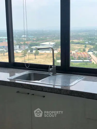 Modern kitchen sink with stunning panoramic view of the cityscape.