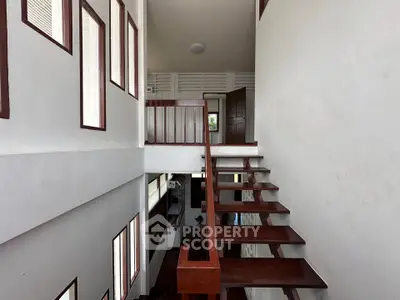 Modern multi-level staircase with wooden steps and white walls in a contemporary home