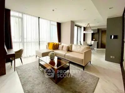 Luxurious modern living room with elegant decor and large windows offering natural light.