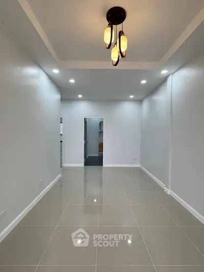 Spacious modern living room with elegant lighting and glossy tiled floors