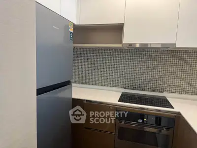 Modern kitchen with sleek appliances and stylish backsplash in a contemporary home.