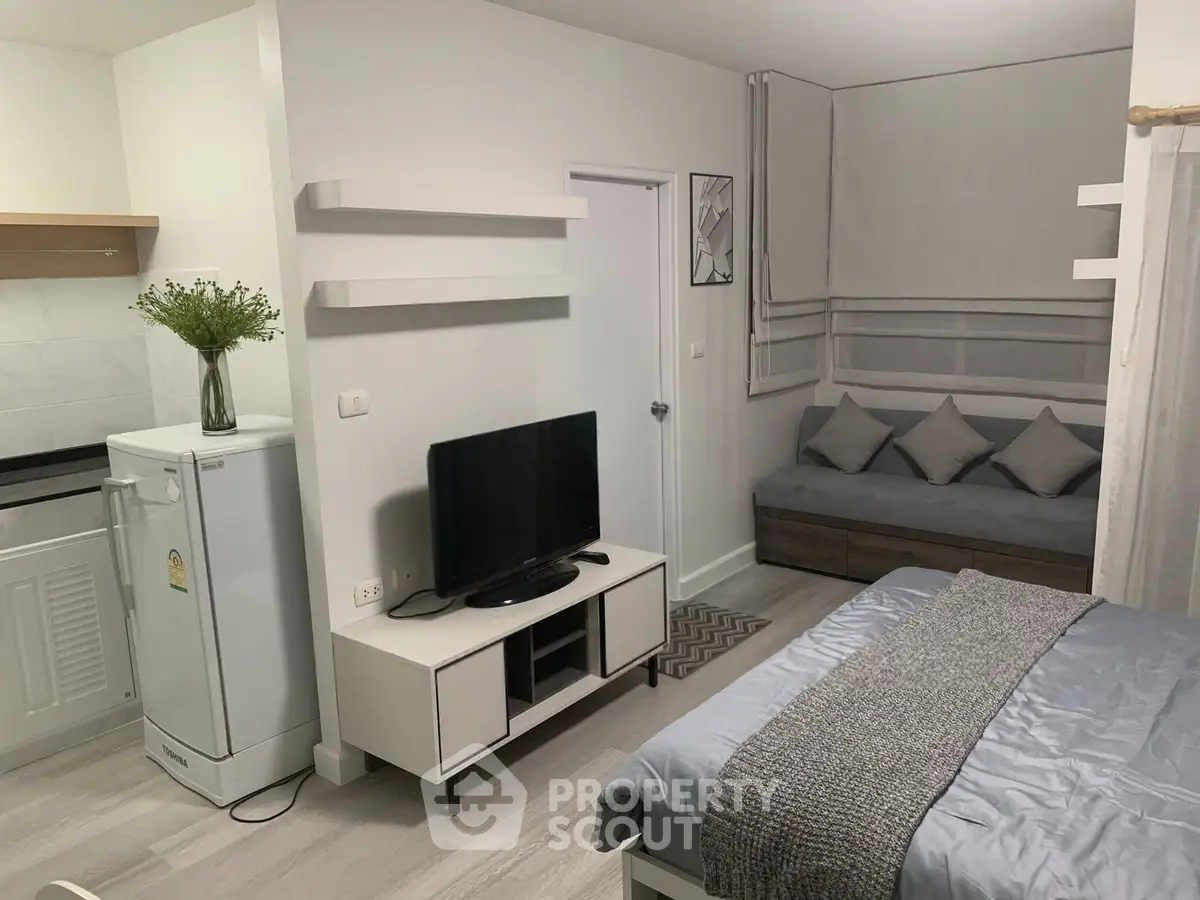 Modern studio apartment with cozy living area and sleek kitchen design.