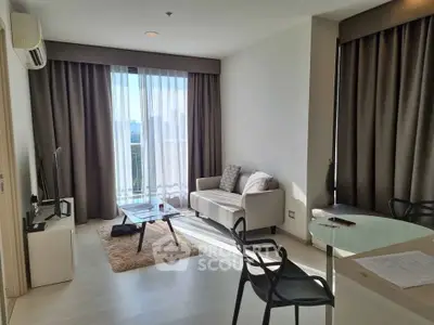 Modern living room with natural light, stylish furniture, and city view from balcony.