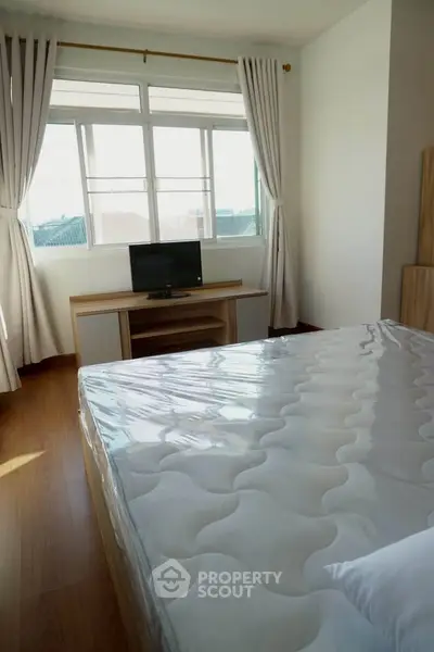 Bright bedroom with large window and modern furnishings