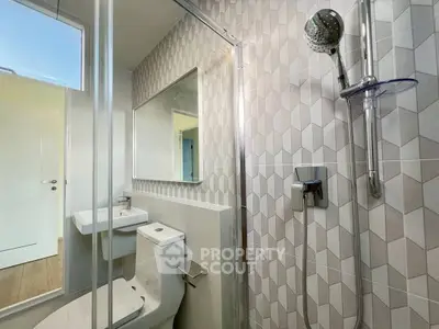 Modern bathroom with geometric tile design and glass shower enclosure