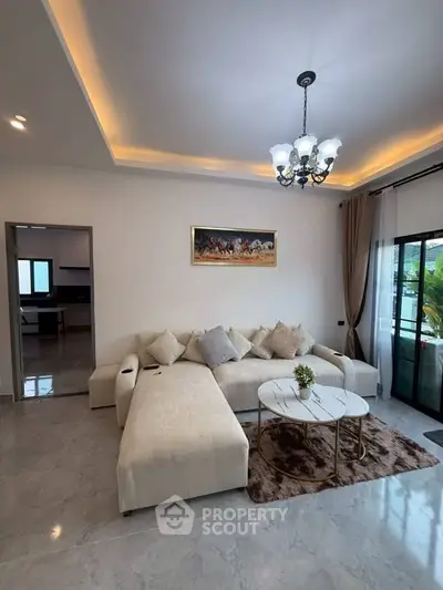 Elegant living room with modern L-shaped sofa and chic chandelier lighting.