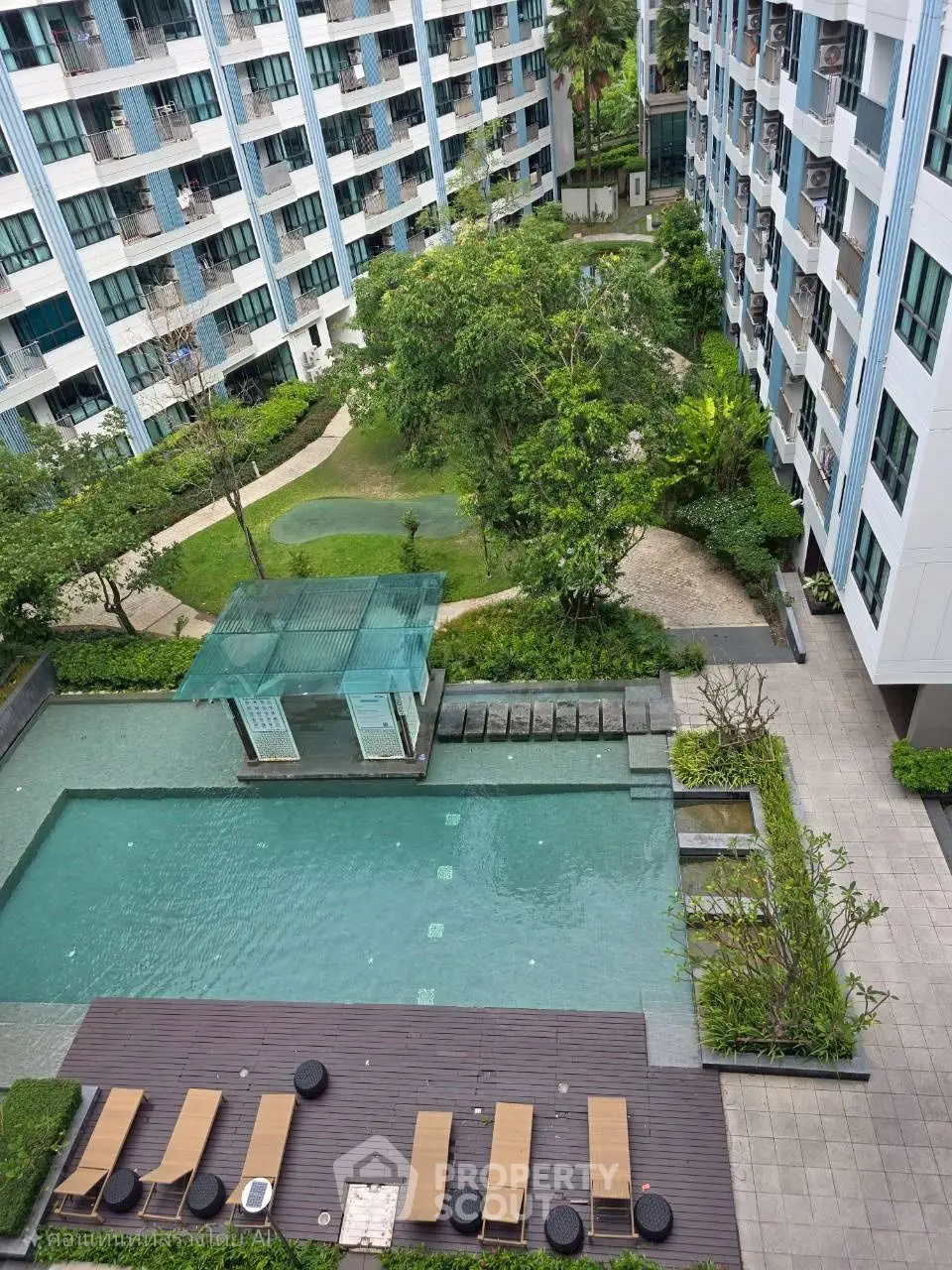 Modern apartment complex with pool and lush garden view