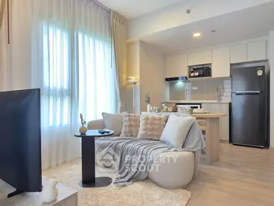 Modern living room with cozy seating and open kitchen layout in a stylish apartment.