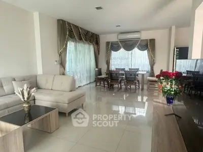 Spacious living room with elegant decor and large windows, perfect for family gatherings.