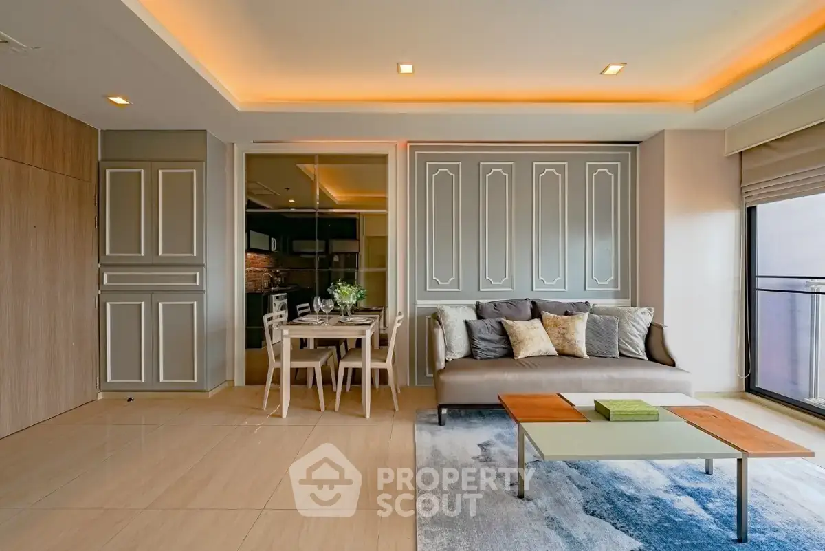 Modern living room with elegant decor and open dining area, featuring stylish furniture and ambient lighting.