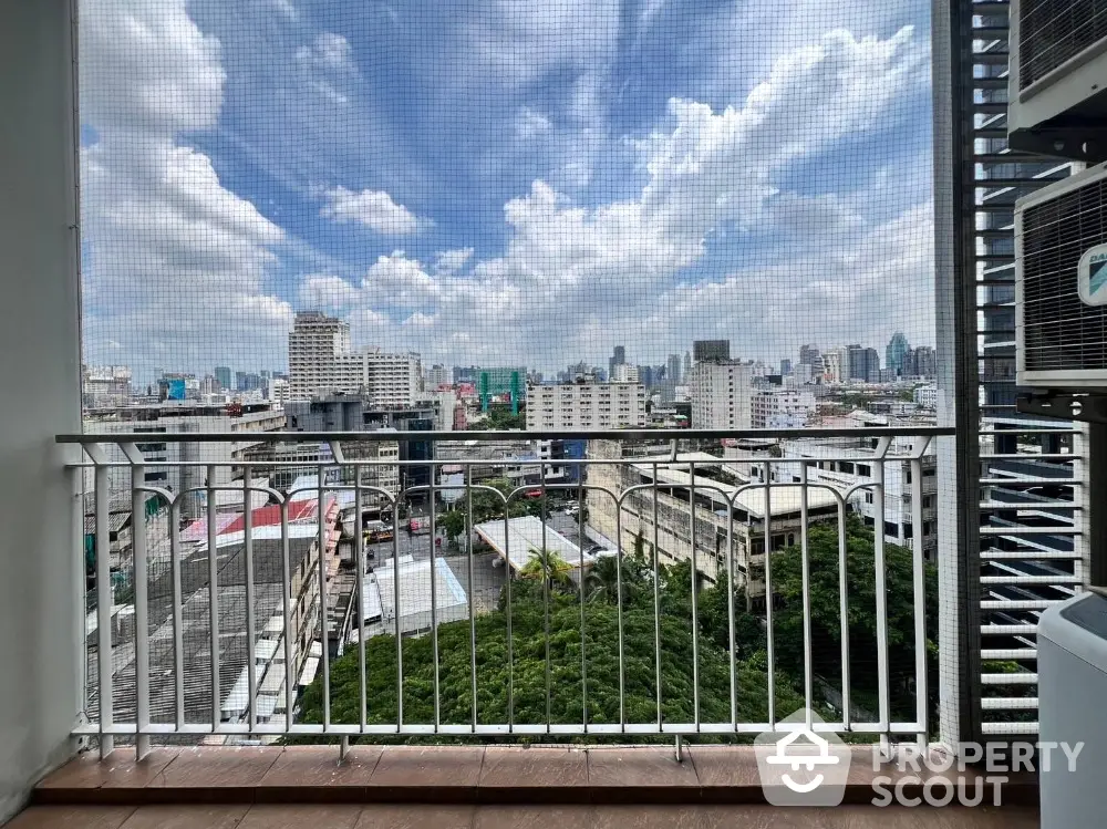 Stunning cityscape view from a high-rise balcony with clear blue skies.