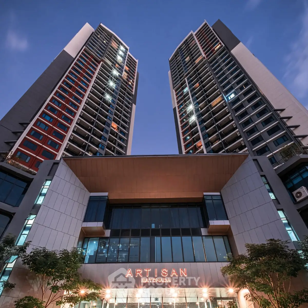 Stunning view of Artisan Ratchada's modern high-rise architecture at dusk.
