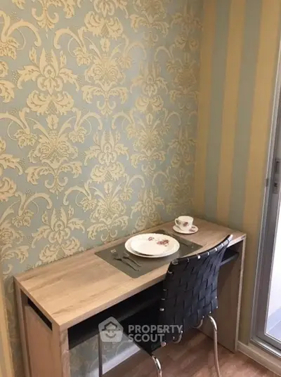 Charming study nook with elegant wallpaper and modern desk in cozy apartment.
