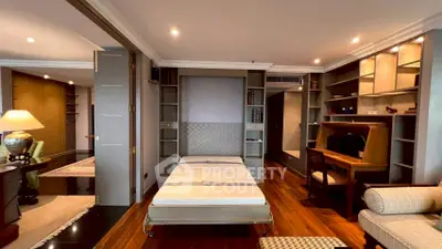 Luxurious multifunctional living space with elegant wooden flooring and built-in shelving.