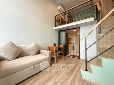 Modern loft apartment with stylish mezzanine and cozy living area, featuring sleek wooden flooring and contemporary furniture.