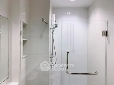 Modern bathroom with sleek glass shower enclosure and white tiles