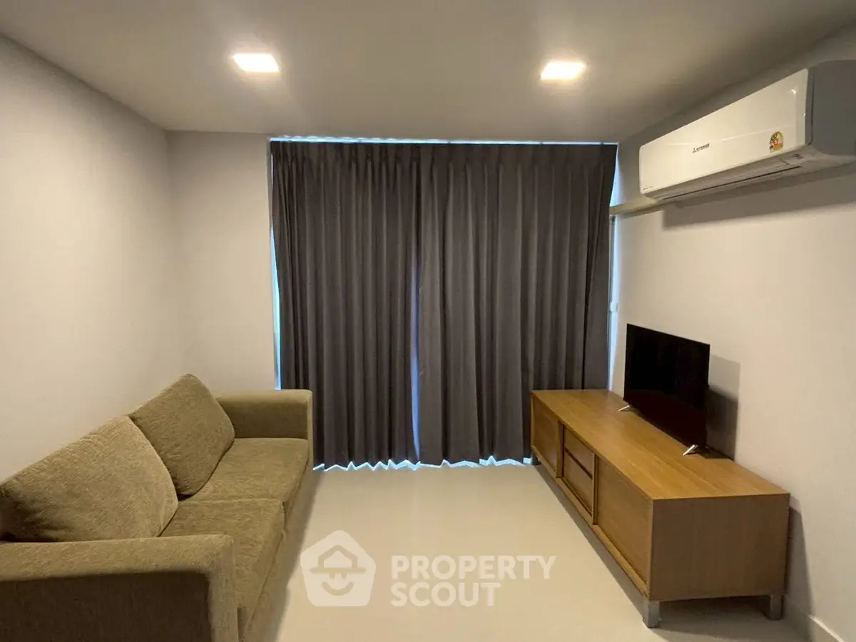 Modern living room with cozy sofa, sleek TV stand, and air conditioning for comfort.