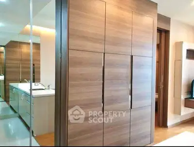 Modern interior with sleek wooden cabinetry and mirrored accents in a stylish apartment.