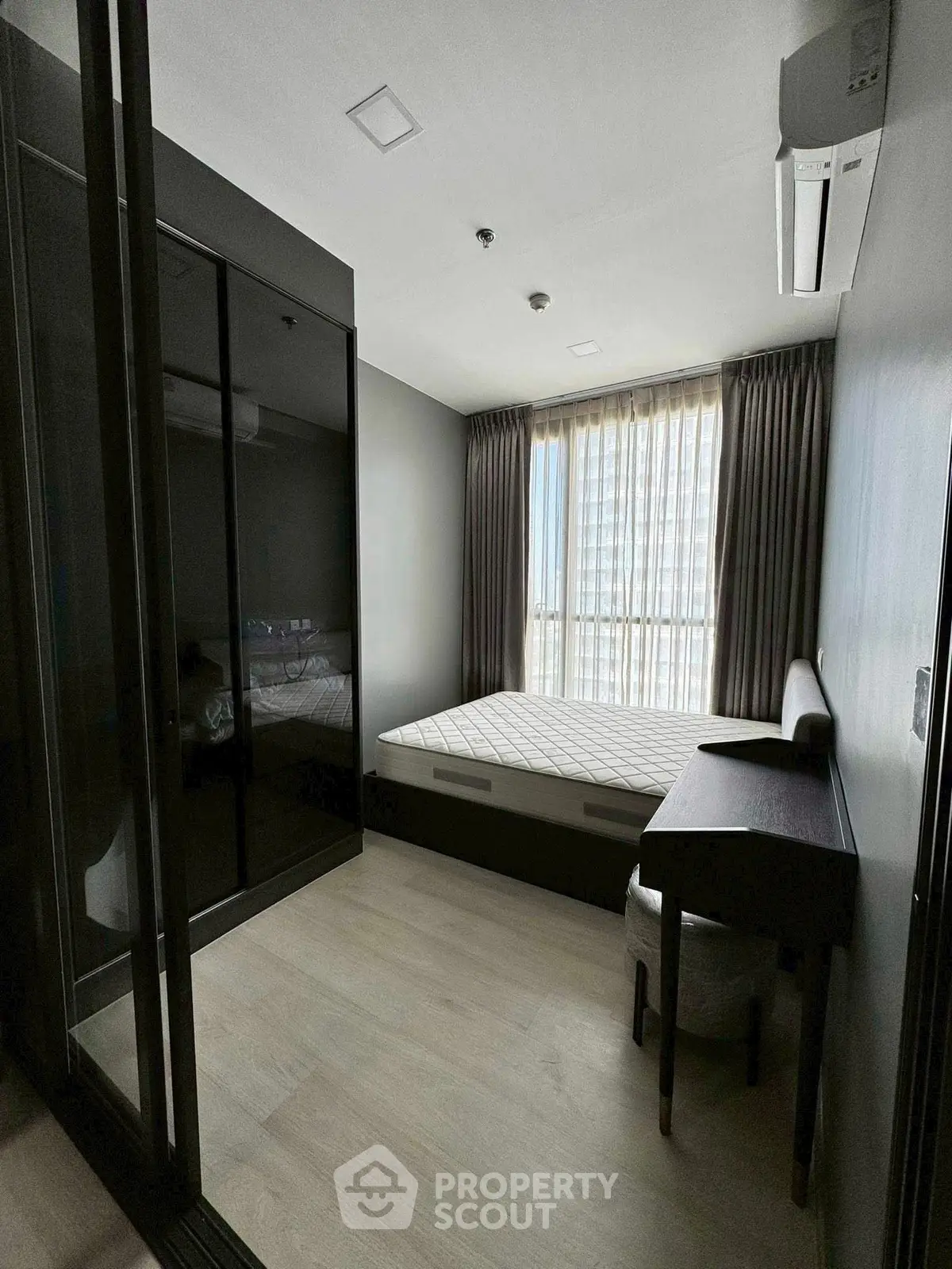 Modern bedroom with sleek design, featuring a large window and stylish furniture.