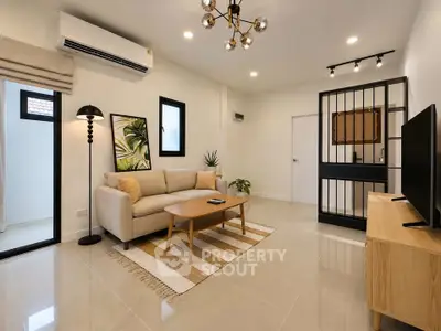 Modern living room with stylish decor, featuring a beige sofa, wooden coffee table, and sleek lighting fixtures.