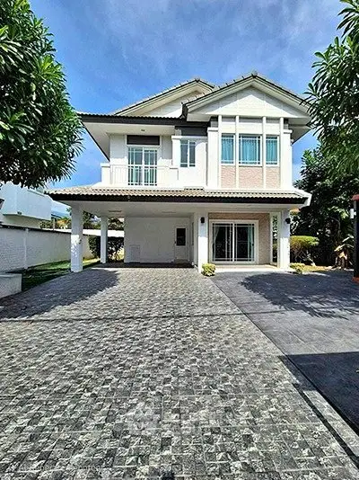 Stunning two-story house with spacious driveway and lush greenery.