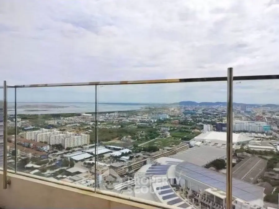 Stunning panoramic cityscape view from high-rise balcony with glass railing.