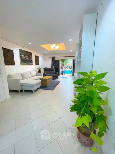 Spacious living room with modern decor and pool view, perfect for relaxation.