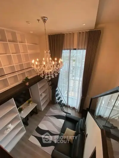 Luxurious loft-style living room with high ceilings and elegant chandelier