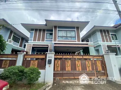 Modern two-story house with elegant facade and secure gated entrance.