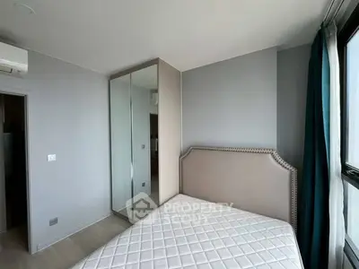 Modern bedroom with mirrored wardrobe and stylish headboard in a bright apartment.