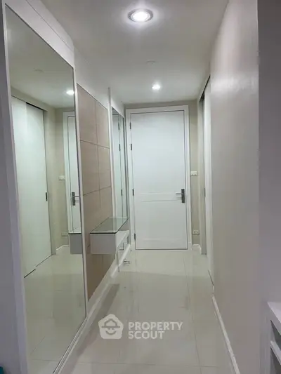 Modern hallway with sleek design and mirrored walls in a contemporary home.