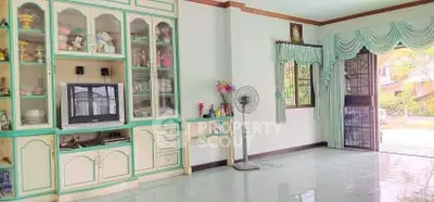 Spacious living room with built-in cabinets and garden view, ideal for family gatherings.