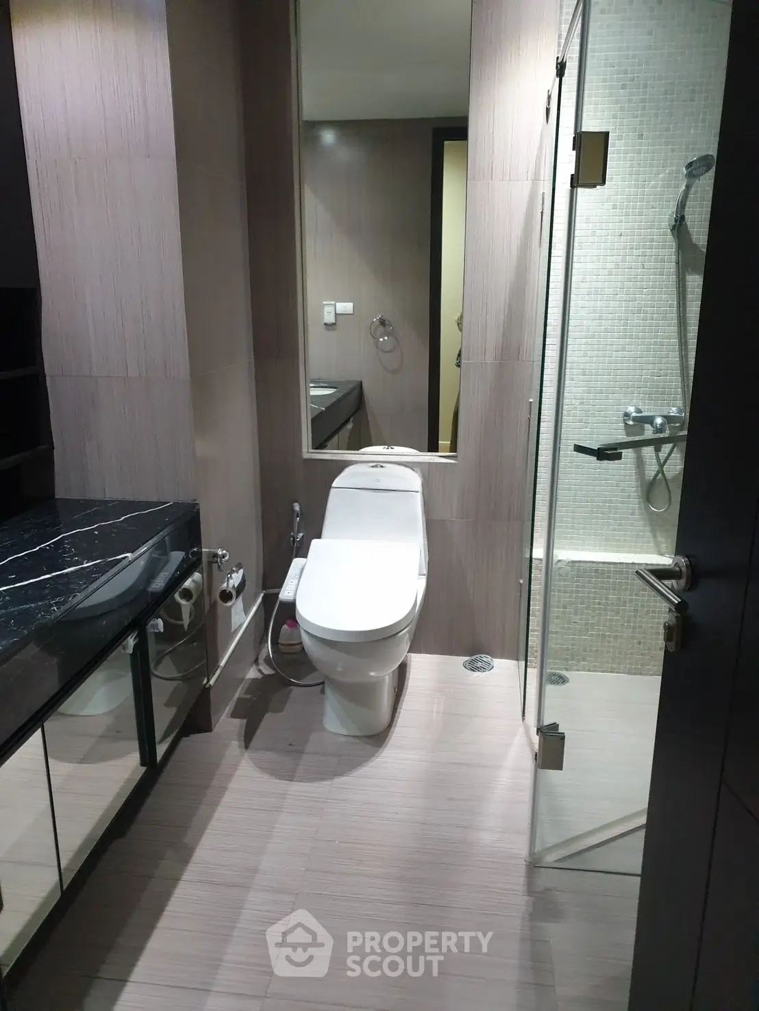 Modern bathroom with sleek design, featuring a glass shower and elegant fixtures.