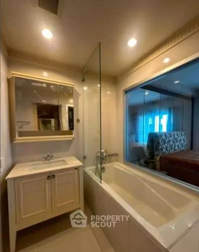 Elegant bathroom with bathtub and glass partition in modern apartment