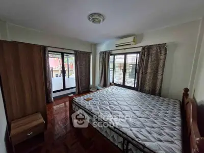 Spacious bedroom with large windows and balcony access