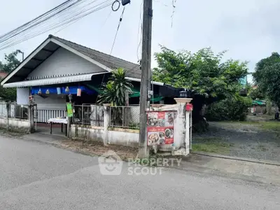 Charming single-story house with lush greenery and fenced yard in a peaceful neighborhood.